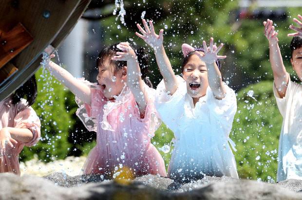 지난해 5월21일 광주 북구청 광장에서 야외활동을 나온 북구청직장어린이집 아이들이 물레방아에서 물장구를 치고 있다. 광주 북구 제공