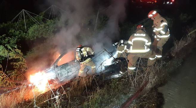 15일 새벽 3시38분쯤 경북 영천시 임고면 한 농로 아래로 떨어진 차량에서 불이나 소방 당국이 진화작업을 벌이고 있다. /경북소방본부