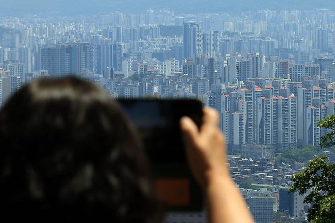 지난 12일 서울 남산을 찾은 시민이 도심 아파트단지 등을 촬영하고 있다. /뉴스1