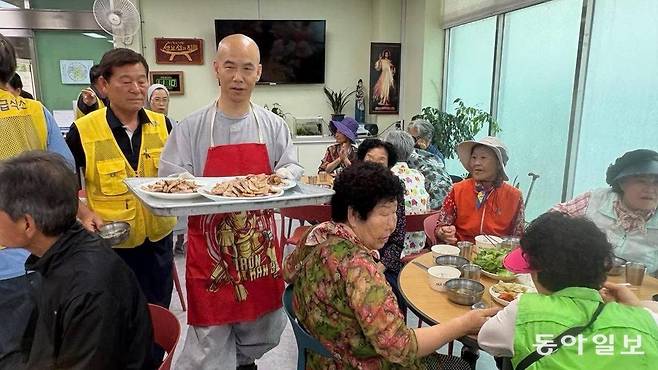 12일 광주 남구 방림2동에 있는 무료급식소 ‘성요셉의 집 사랑의 식당’에서 문빈정사 법공 주지스님과 신도들이 삼겹살을 구워 어르신들에게 점심을 대접하고 있다. 사랑의 식당 제공