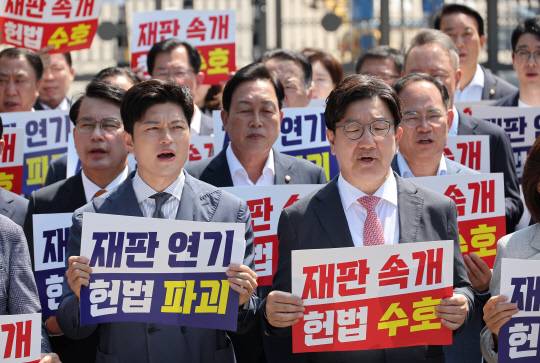 김용태 국민의힘 비상대책위원장과 권성동 원내대표가 지난 11일 이재명 대통령의 공직선거법 위반 사건의 파기환송심을 사실상 무기한 연기한 서울고등법원 앞에서 열린 현장 의원총회에서 구호를 외치고 있다. [연합뉴스]