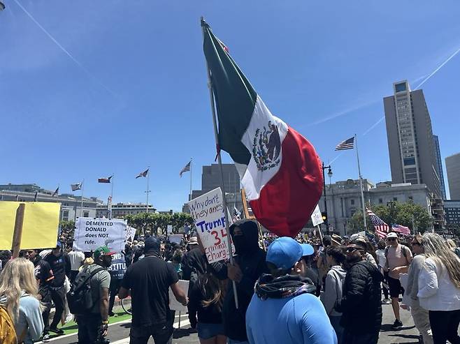14일(현지시간) 미국 샌프란시스코 시청 광장에서 열린 '노킹스'(No Kings·왕은없다) 시위에서 한 히스패닉 시위자가 멕시코 국기를 쥐고 흔들고 있다. 사진=홍창기 기자