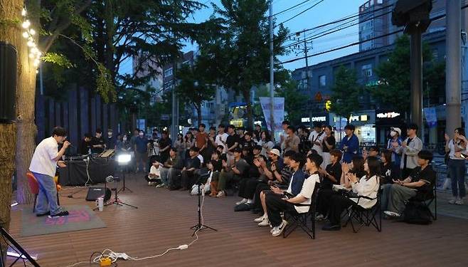 지난 12일 2025 부산 남구 대학로 버스킹 존이 개소한 가운데 이날 저녁 첫 공연으로 인디 뮤지션 ‘#안녕’이 관객들 앞에서 공연하고 있는 모습. 부산 남구 제공