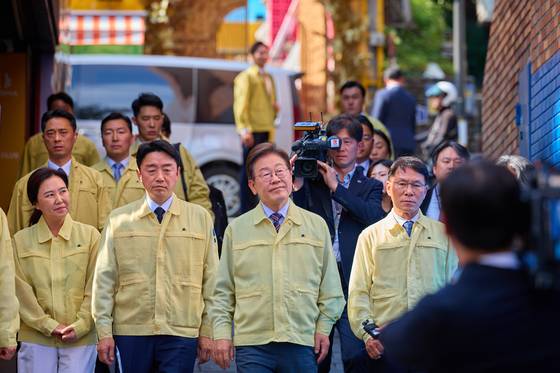 이재명 대통령이 12일 서울 용산구 세계음식문화의 거리, 이태원 참사 현장 '10·29 기억과 안전의 길'을 살피보고 있다. [사진 대통령실]