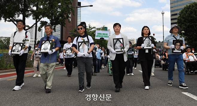 민족민주열사·희생자 유가족들이 15일 ‘제34회 민족민주열사·희생자 범국민 추모제’ 시작에 앞서 서울 광화문에서 영정사진을 가슴에 안고 거리행진을 하고 있다. 서성일 선임기자