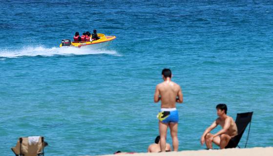 With temperatures soaring above 30 degrees Celsius (86 degrees Fahrenheit), people at Gyeongpo Beach in Gangneung, Gangwon, bask under the blazing sun and enjoy boat rides, embracing the summer heat. [YONHAP]