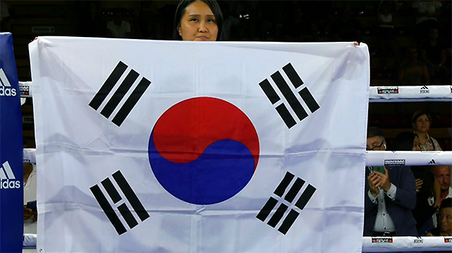2025년 6월 이탈리아 노바라 ‘팔라이고르 고르곤촐라’ 세계복싱협회 여자 플라이급 골드타이틀매치 시작 전 대한민국 국민의례를 위해 펼쳐진 태극기. 사진=이탈리아복싱연맹(Federazione Pugilistica Italiana) 영상 화면