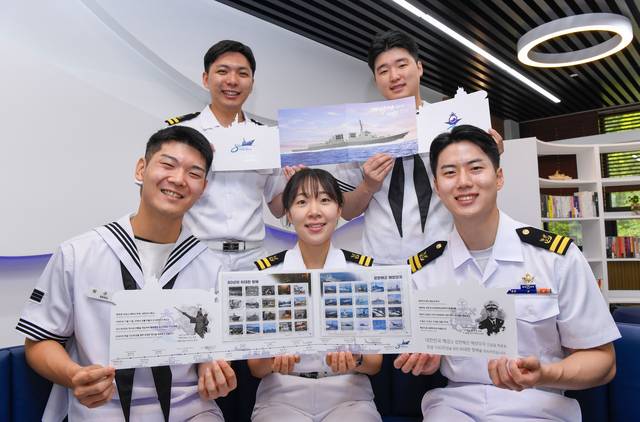 해군본부에서 해군창설 80주년을 기념해 발행한 ‘대한민국해군 80년 위대한 항해’ 우표첩을 해군 장병들이 펼쳐 보이며 소개하고 있다. 해군 제공
