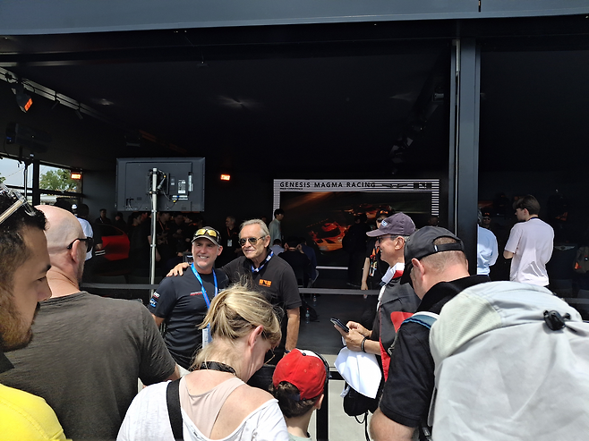 13일(현지시간) 프랑스 르망에서 마련된 제네시스 마그마 레이싱 부스에 자리한재키 익스(사진 가운데) 공식 파트너가 팬들과 기념사진을 촬영하고 있다. [프랑스 르망=김성우 기자]