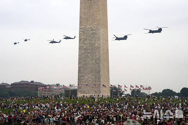 [워싱턴=AP/뉴시스] 14일(현지 시간) 워싱턴에서 열린 미 육군 창설 250주년 기념 군사 열병식에서 미 육군 제160특수작전항공연대 소속 헬리콥터들이 워싱턴 기념비 주변을 비행하고 있다. 왼쪽부터 MH-6 리틀버드, MH-60 블랙호크, MH-47 치누크. 2025.06.15.