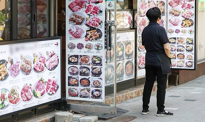 내수 경기 침체 장기화로 인해 숙박·음식점업 대출 잔액이 처음으로 90조 원을 넘어서면서 소상공인 위기가 깊어지고 있다. 지난 12일 서울 중구 명동의 한 식당에서 한 자영업자가 손님을 기다리고 있다. 뉴스1