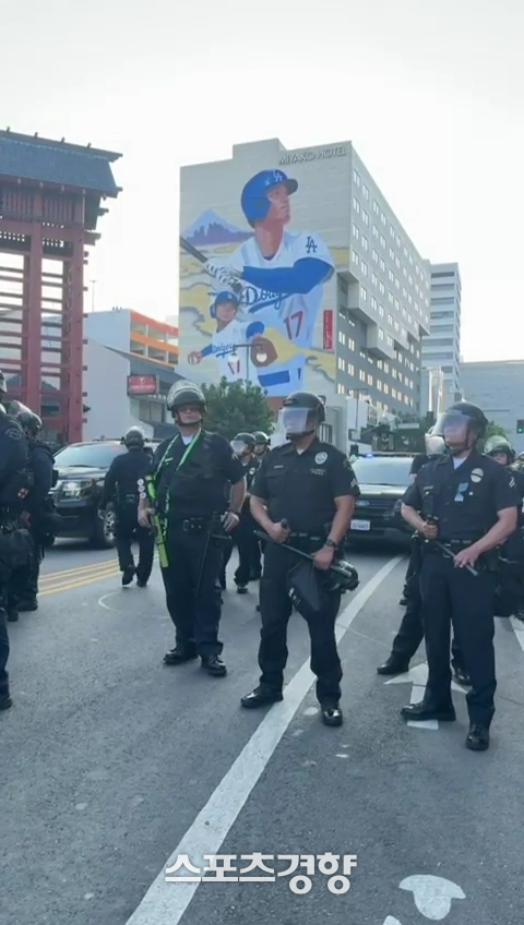 LA 경찰들이 지난 9일 오타니 쇼헤이의 벽화 앞에서 시위 진압 장비를 착용한 채 늘어서 있다. 뉴욕타임스 제공