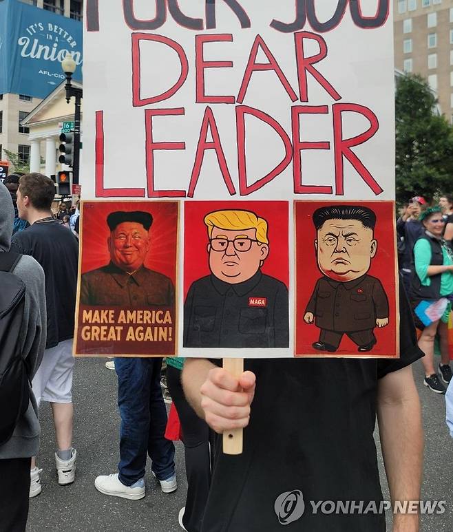 트럼프-김정은 '합성' 만화 그려진 피켓 든 시위 참가자 (워싱턴=연합뉴스) 조준형 특파원 = 14일(현지시간) 워싱턴 DC에서 열린 미 육군 창설 250주년 기념 열병식을 앞두고 백악관 인근 라파예트 광장에서 반(反)트럼프 시위가 열렸다. 
    한 시위 참가자가 트럼프 대통령과 김정은 북한 국무위원장의 얼굴을 '합성'한 만화가 그려진 피켓을 들고 있다. 2025.6.15 jhcho@yna.co.kr
