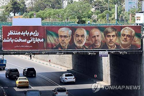 테헤란 다리에 걸린 사망한 이란 군 장성과 핵과학자의 모습 [AFP 연합뉴스 자료사진. 재판매 및 DB 금지]