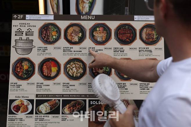지난 16일 오후 서울 중구 명동에서 한 관광객이 음식 안내판을 살펴보고 있다.(사진=이데일리 노진환 기자)