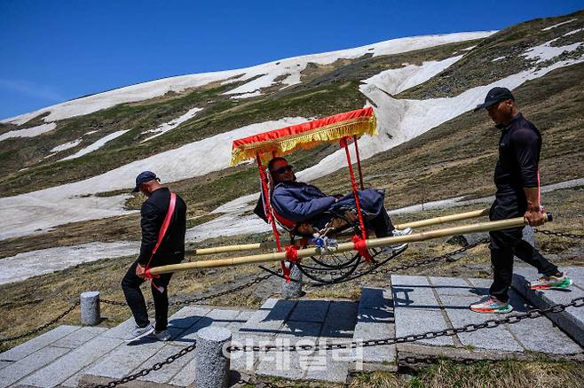 지난 12일 백두산 천지 서파지역에서 가마꾼이 손님을 태우고 이동하고 있다.