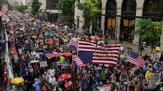 14일(현지시간) 미국 뉴욕에서 시위대가 저항의 의미를 담아 성조기를 거꾸로 들고 거리 행진을 하고 있다. 2025.6.14 ⓒ 로이터=뉴스1 ⓒ News1 류정민 특파원