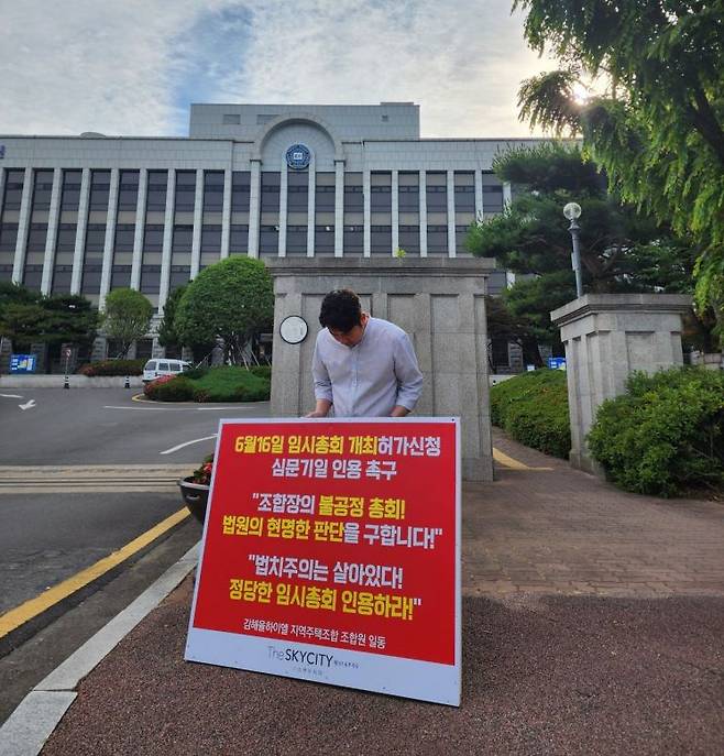 경남 김해시 율하더스카이시티 제니스&프라우 조합원이 김해율하이엘지역주택조합 임시총회 소집 허가를 법원에 촉구하는 1인 시위를 벌이고 있다. 김해율하이엘지역주택조합 제공