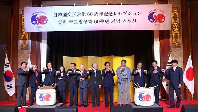 16일 서울 중구 롯데호텔에서 열린 한일 국교정상화 60주년 기념 행사에서 미즈시마 고이치 주한일본대사와 김진아 외교부 2차관을 포함한 참가자들이 건배하며 기념촬영을 하고 있다. 연합뉴스
