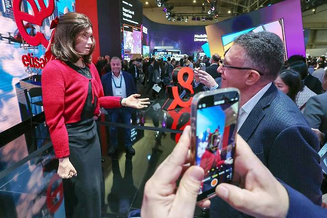스페인 바르셀로나에서 열린 MWC 2025 행사 참가자들이 AI 로봇과 대화를 나누고 있다.