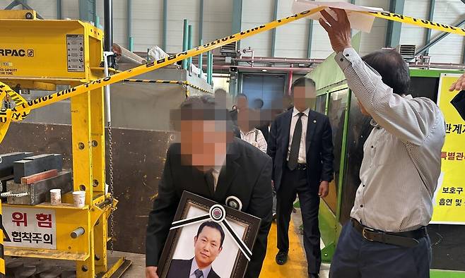 지난 3일 고 김충현 노동자 유족 등이 김씨 영정을 안고 사고 현장인 태안화력발전소 기계공작실을 둘러보고 있다. 송인걸 기자
