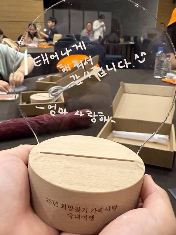 이번 여행에 참여한 한 학생이 엄마에게 전하는 메시지를 LED 등에 새겨 보여주고 있다 [사진=달성군]