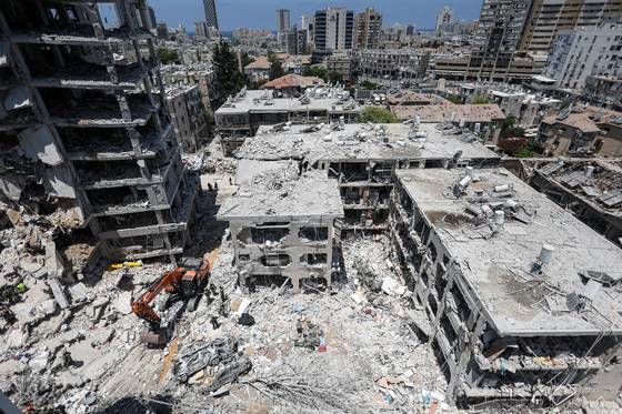 이란의 미사일 공격에 파괴된 이스라엘 중부 지역의 한 아파트에서 구조 작업을 벌이는 모습. [로이터=연합뉴스]