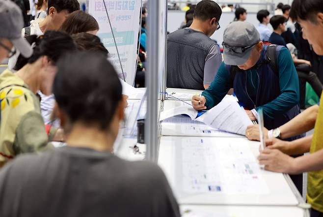지난 11일 경기도 하남종합운동장 제2체육관에서 열린 2025 하남시 일자리박람회에서 고령 구직자가 이력서를 작성하고 있다. 연합뉴스.