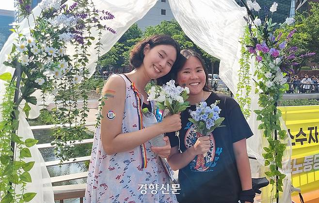 14일 서울 중구 ‘제26회 서울퀴어퍼레이드’ 장소 인근에서 ‘마당극 민중의 부활’이 운영하던 부스에 생활동반자신고서를 낸 김은지씨(29)와 지구(24·활동명)가 기념 사진을 찍고 있다. 강한들 기자