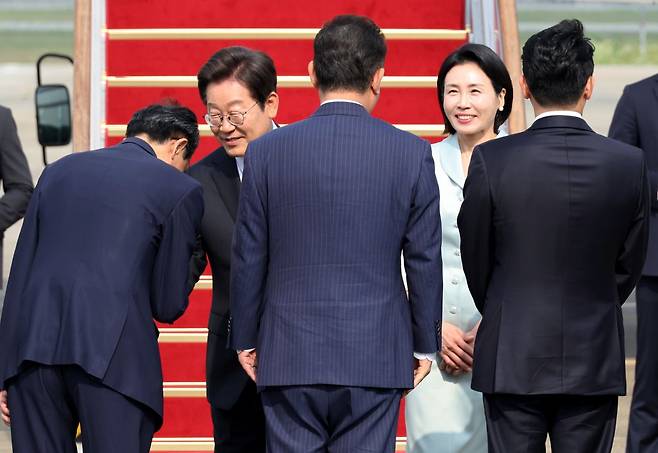 주요 7개국(G7) 정상회의에 참석하는 이재명 대통령이 김혜경 여사와 16일 성남 서울공항 공군 1호기에 탑승하기 앞서 우상호 대통령실 정무수석과 인사하고 있다. 연합뉴스