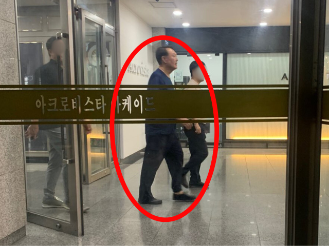 지난 13일 서울 서초구 아크로비스타 지하 아케이드에서 윤석열 전 대통령이 경호원을 대동하고 지나가고 있는 모습이 포착된 사진이 온라인에서 확산 중이다. [X 갈무리]