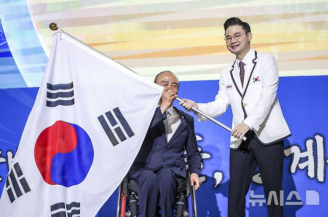 [서울=뉴시스] 정병혁 기자 = 정진완 대한장애인체육회장이 12일 서울 송파구 올림픽파크텔에서 열린 2024 파리 패럴림픽대회 대한민국 선수단 결단식에서 배동현 선수단장에게 단기를 전달하고 있다. 2024.08.12. jhope@newsis.com