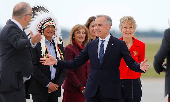 올해 G7 정상회의 의장국인 캐나다의 마크 카니 총리(가운데)가 회의 장소인 앨버타주의 휴양 도시 카나나스키스와 가까운 캘러리 국제공항에 착륙한 뒤 두 팔을 벌려 환영객들에게 인사하고 있다. 지난 3월 취임한 카니 총리는 이번이 첫번째 G7 회의&nbsp;참석에 해당한다. 그뿐 아니고 키어 스타머&nbsp;영국 총리, 프리드리히 메르츠 독일 총리, 이시바 시게루 일본 총리도 생애 최초로 G7 무대를 밟는다. AFP연합뉴스