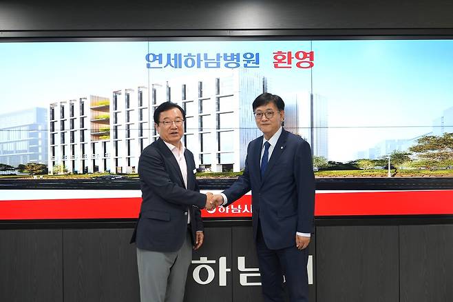 이현재 하남시장(왼쪽)과 재단법인 천안공원 관계자가 종합병원 설립 업무협약을 맺은 뒤 악수하고 있다. 하남시 제공