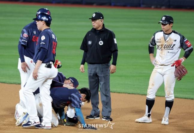 롯데 장두성(왼쪽에서 4번째)이 12일 수원 KT전 10회초 1사에서 박영현에게 공에 맞은 뒤 고통스러워하고 있다. /사진=강영조 선임기자