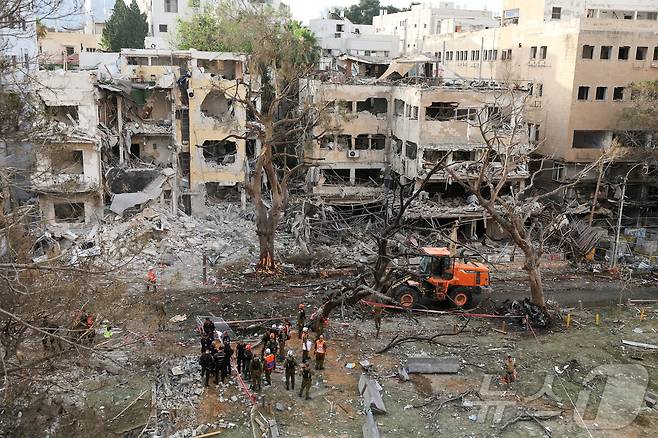 16일 이란이 이스라엘 텔아비브를 향해 미사일이 발사한 후 긴급 구조대가 손상된 건물에 출동해 있다. 2025.6.16 ⓒ 로이터=뉴스1 ⓒ News1 강민경 기자