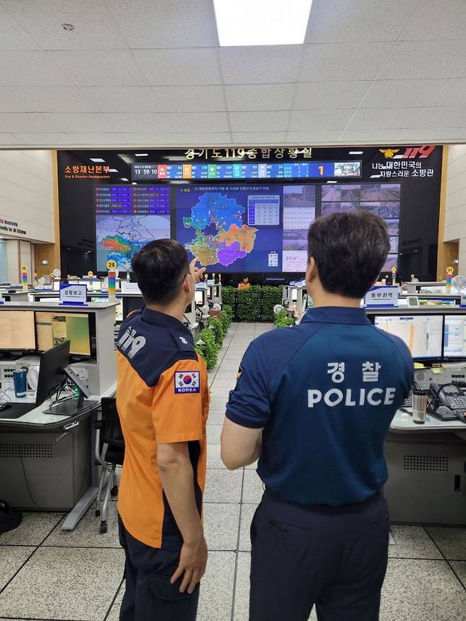 경기도소방재난본부 119종합상황실에 파견된 경찰 협력관이 담당자로부터 설명을 듣고 있다. 경기도소방재난본부 제공