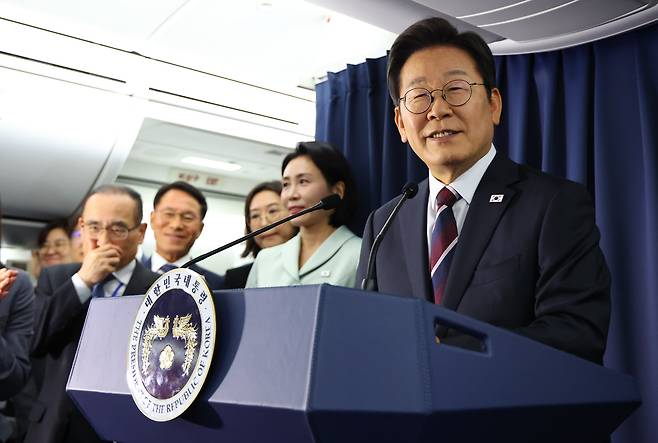 이재명 대통령이 16일(현지 시각) G7 정상회의가 열리는 캐나다로 이동하는 전용기 안에서 기자회견을 하며 질문에 답하고 있다./뉴시스