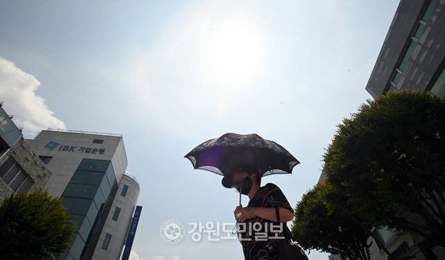 ▲ 한낮 자외선 지수가 매우 높음 수준을 보인 17일 강원 춘천시 중앙로에서 한 시민이 양산을 쓰고 횡단보도를 건너고 있다. 방도겸 기자