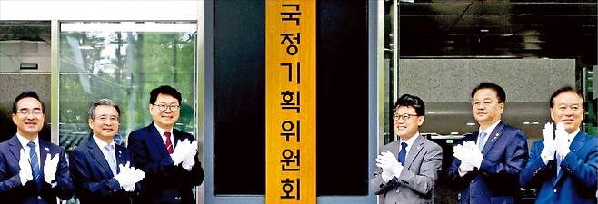 < 서울청사서 현판식 > 이재명 정부 대통령직인수위원회 역할을 할 국정기획위원회가 출범한 16일 정부서울청사 창성동 별관에서 참석자들이 현판식을 하고 있다. 왼쪽부터 박홍근 더불어민주당 의원, 김용범 대통령실 정책실장, 이한주 국정기획위원장, 진성준 민주당 정책위원회 의장, 방기선 국무조정실장, 정태호 민주당 의원.  김범준 기자