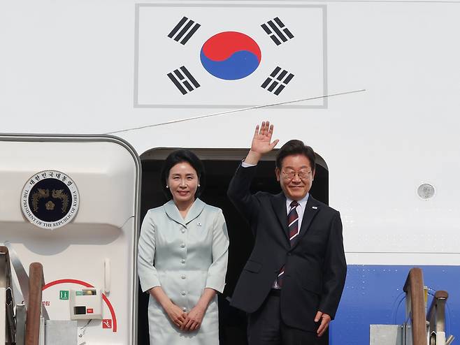 President Lee Jae-myung and first lady Kim Hye-kyung wave before boarding Air Force One at Seoul Air Base in Seongnam, Gyeonggi Province, on Monday afternoon. (Yonhap)