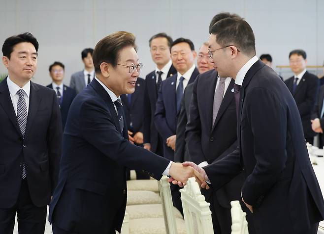 President Lee Jae Myung shakes hands with LG Group Chairman Koo Kwang-mo at a meeting with major conglomerate and business organization heads at the presidential office in Yongsan, central Seoul, on June 13. [JOINT PRESS CORPS]