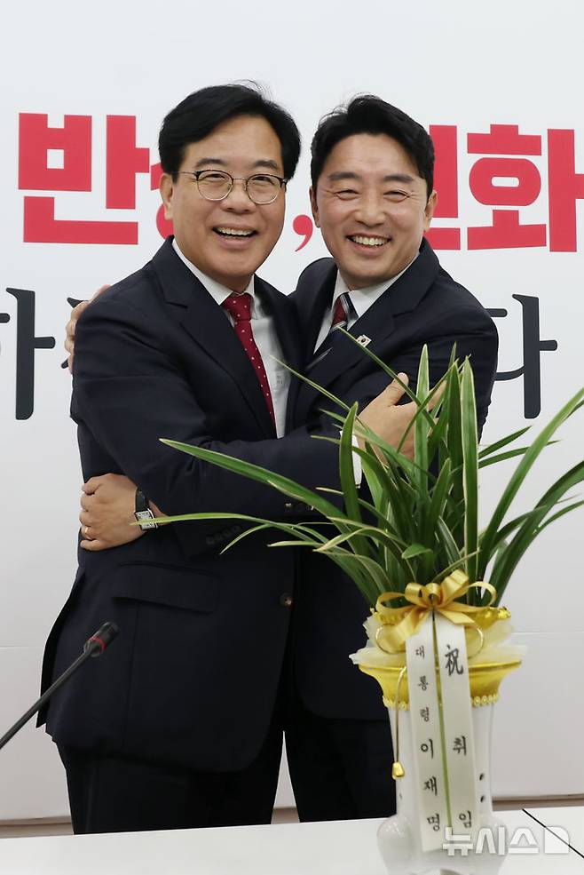 [서울=뉴시스] 고승민 기자 = 송언석 국민의힘 원내대표와 강훈식 대통령 비서실장이 17일 서울 여의도 국회에서 만나 포옹하며 기념촬영하고 있다. 2025.06.17. kkssmm99@newsis.com