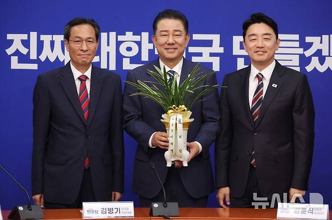 [서울=뉴시스] 조성봉 기자 = 김병기(가운데) 더불어민주당 당대표 직무대행 겸 원내대표가 17일 서울 여의도 국회에예방온 강훈식 대통령실 비서실장과 우상호(왼쪽) 정무수석에게 이재명 대통령의 축하 난을 전달받고 기념촬영을 하고 있다. 2025.06.17. suncho21@newsis.com