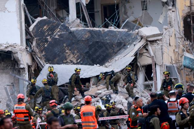 16일(현지 시간) 이스라엘 텔아비브에서 구조 대원들이 이란 미사일에 맞아 파손된 건물 잔해 더미에서 구조 작업을 벌이고 있다. AFP연합뉴스