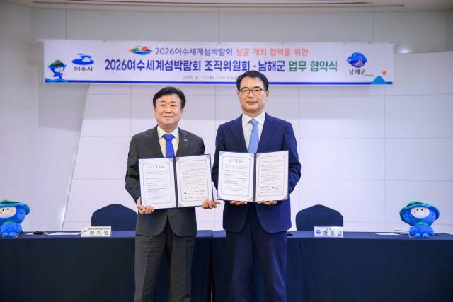 정기명 여수시장(좌)과 장충남 남해군수(우)가 업무협약을 체결한 뒤 기념촬영을 하고 있다. 남해군 제공