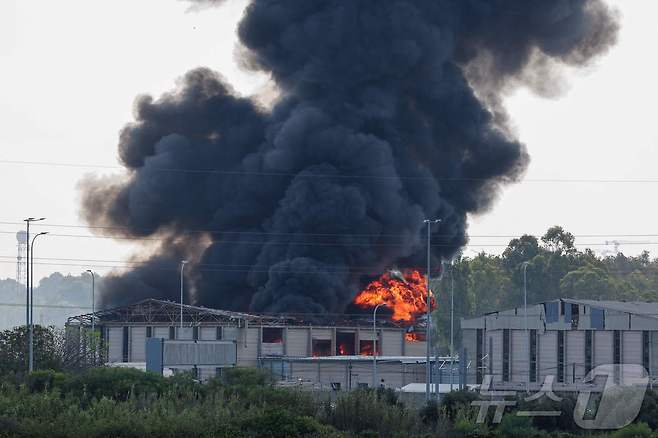 17일(현지시간) 이란의 로켓 공격이 새로 시작되면서 이스라엘 텔아비브 인근 헤르츨리야의 한 건물에서 불길이 솟아오르고 있다. 2025.06.17. ⓒ AFP=뉴스1