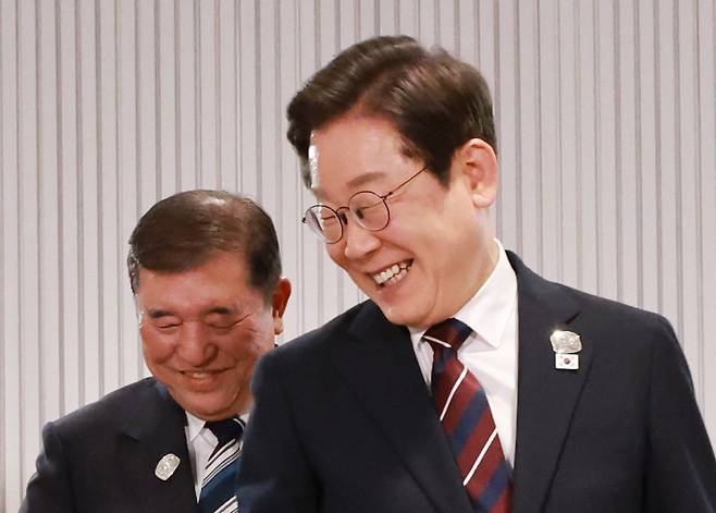 이재명 대통령이 17일 캐나다 앨버타주 캐내내스키스 주요 7개국(G7) 정상회의장에서 열린 한일 정상회담에서 이시바 시게루 일본 총리와 자리를 바꾸며 밝게 웃고 있다. /뉴시스