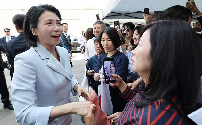 G7 정상회의에 참석하는 이재명 대통령과 함께 캐나다를 방문한 김혜경 여사가 17일(현지시간) 캘거리 한인회관에서 환영나온 주민들의 요청에 티셔츠에 서명하고 있다. ⓒ연합뉴스