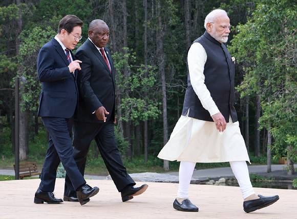 이재명 대통령과 시릴 라마포사 남아프리카공화국 대통령이 17일(현지시간) 캐나다 앨버타주 캐내내스키스 주요 7개국(G7) 정상회의장에서 G7 및 초청국 기념촬영을 위해 이동하며 대화하고 있다. 앞쪽은 나렌드라 모디 인도 총리. 2025.6.18 [사진=연합뉴스]